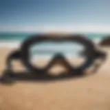 Stylish body surfing goggles resting on a sandy beach