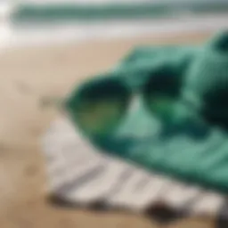 Stylish emerald green sunglasses resting on a beach towel