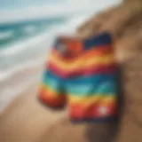 Vibrant board shorts displayed on a sandy beach with ocean waves