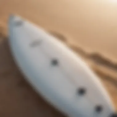 Close-up of surfboard and sunscreen on a sandy beach