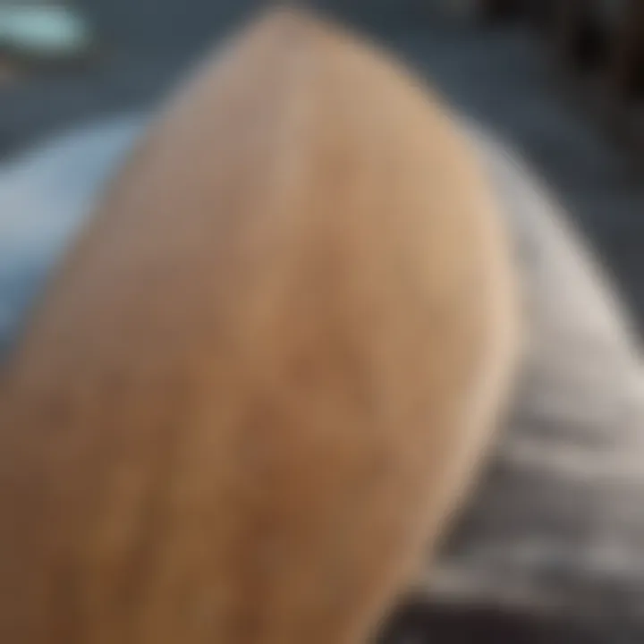 A close-up view of a hard top surfboard showcasing its smooth finish and construction details.