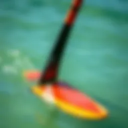 A close-up view of a surf foil submerged in water, showcasing its sleek design