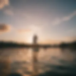 An individual paddleboarding on a serene lake at sunset