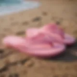 Stylish pink Sanuk flip flops on a beach