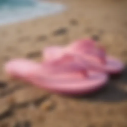 Stylish pink Sanuk flip flops on a beach